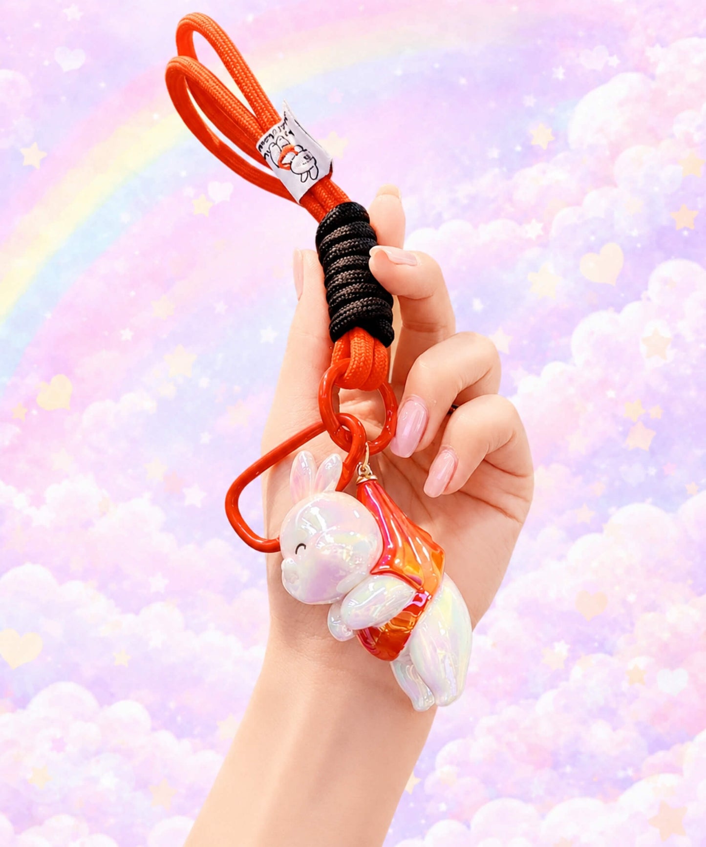 Red iridescent bunny resin keychain held in hand