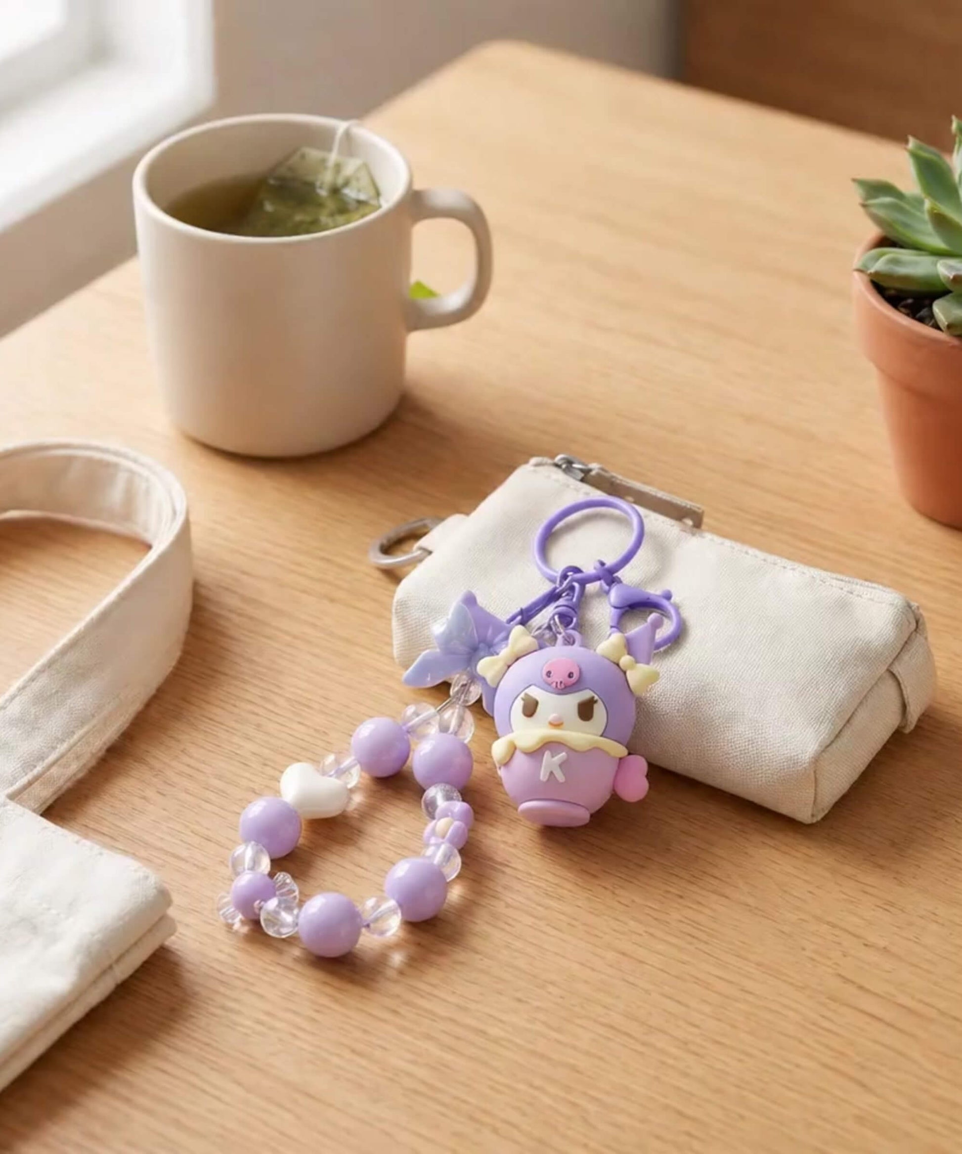 Kuromi purple beaded keychain styled on a small pouch with a cosy table setting
