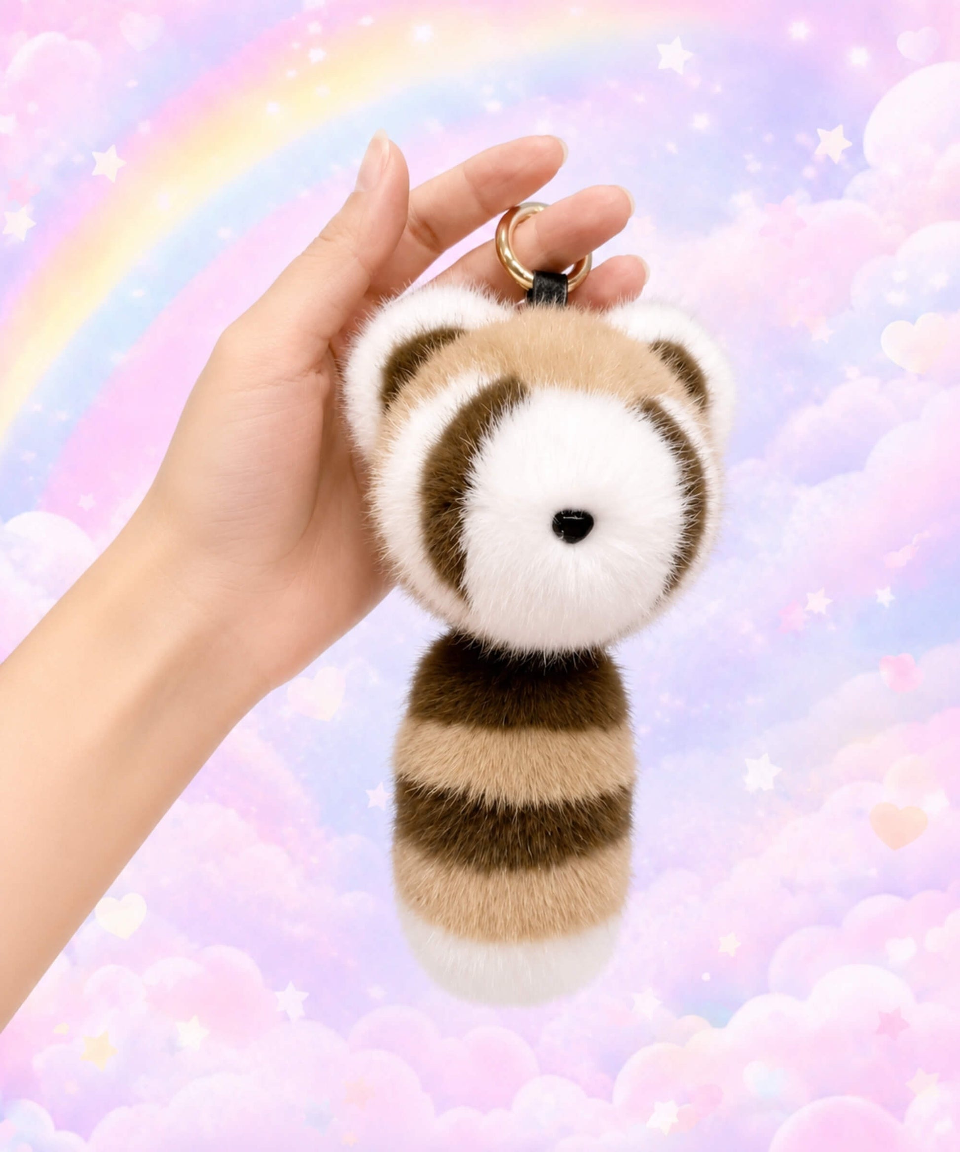 Brown raccoon plush keychain held in hand