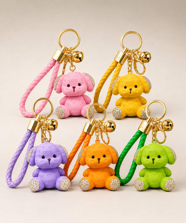 Pink, yellow, purple, orange and green love puppy resin keychains on a neutral background.