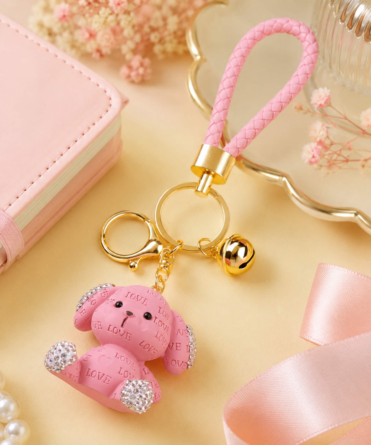 Pink love puppy resin keychain styled in a soft pastel flat lay scene.