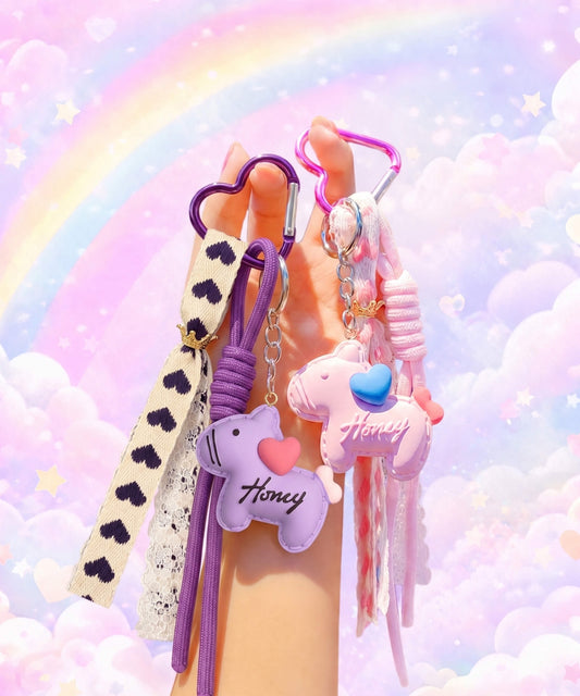 Pink and purple pony phone charms held in hand