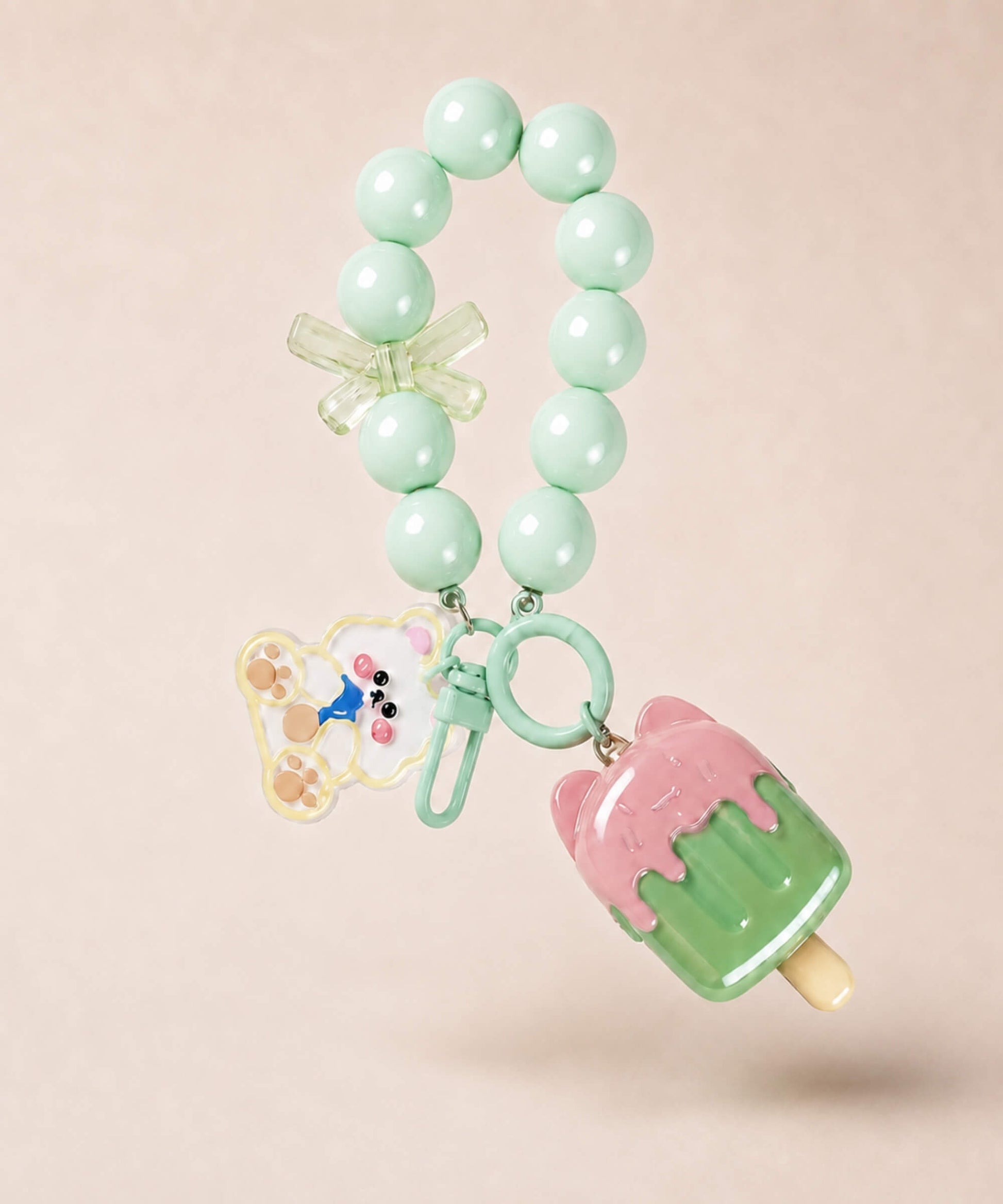 Mint ice cream beaded keychain with green beads and bear charm on a neutral background