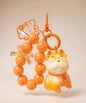 Orange French Bulldog beaded keychain with glasses, bead loop and bunny charm on a neutral background