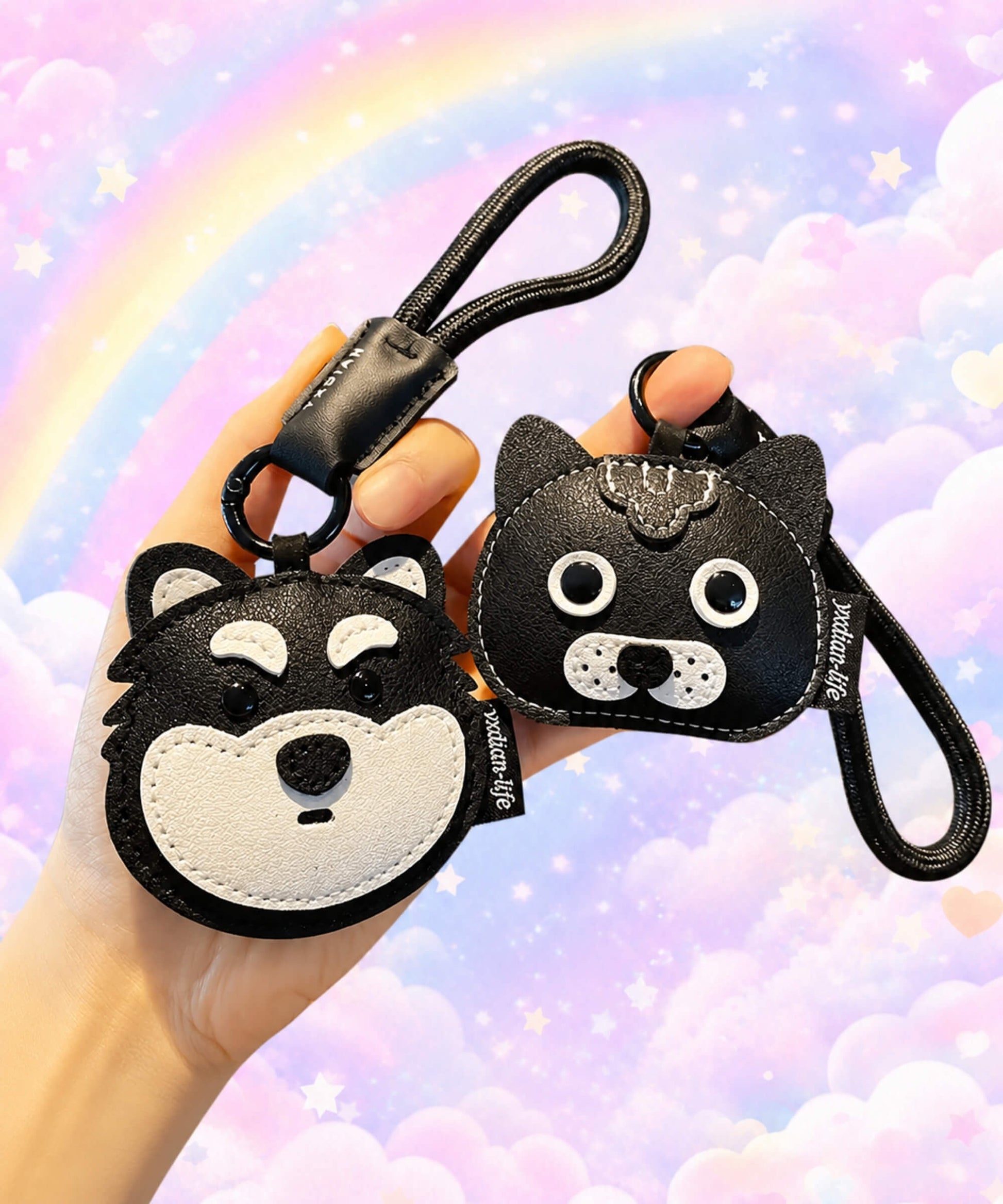 Hand holding husky and black cat pet face PU leather bag charm keychains against a pastel rainbow background.