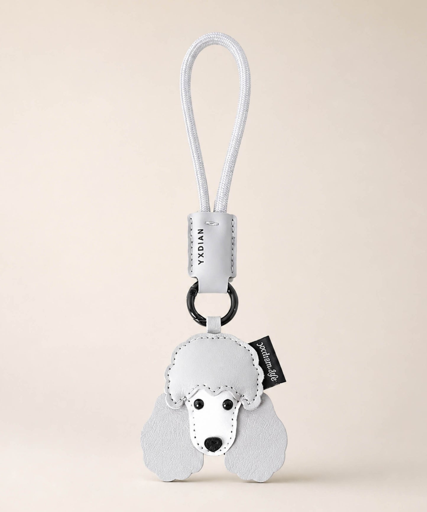 Poodle pet face PU leather bag charm keychain on a neutral background.
