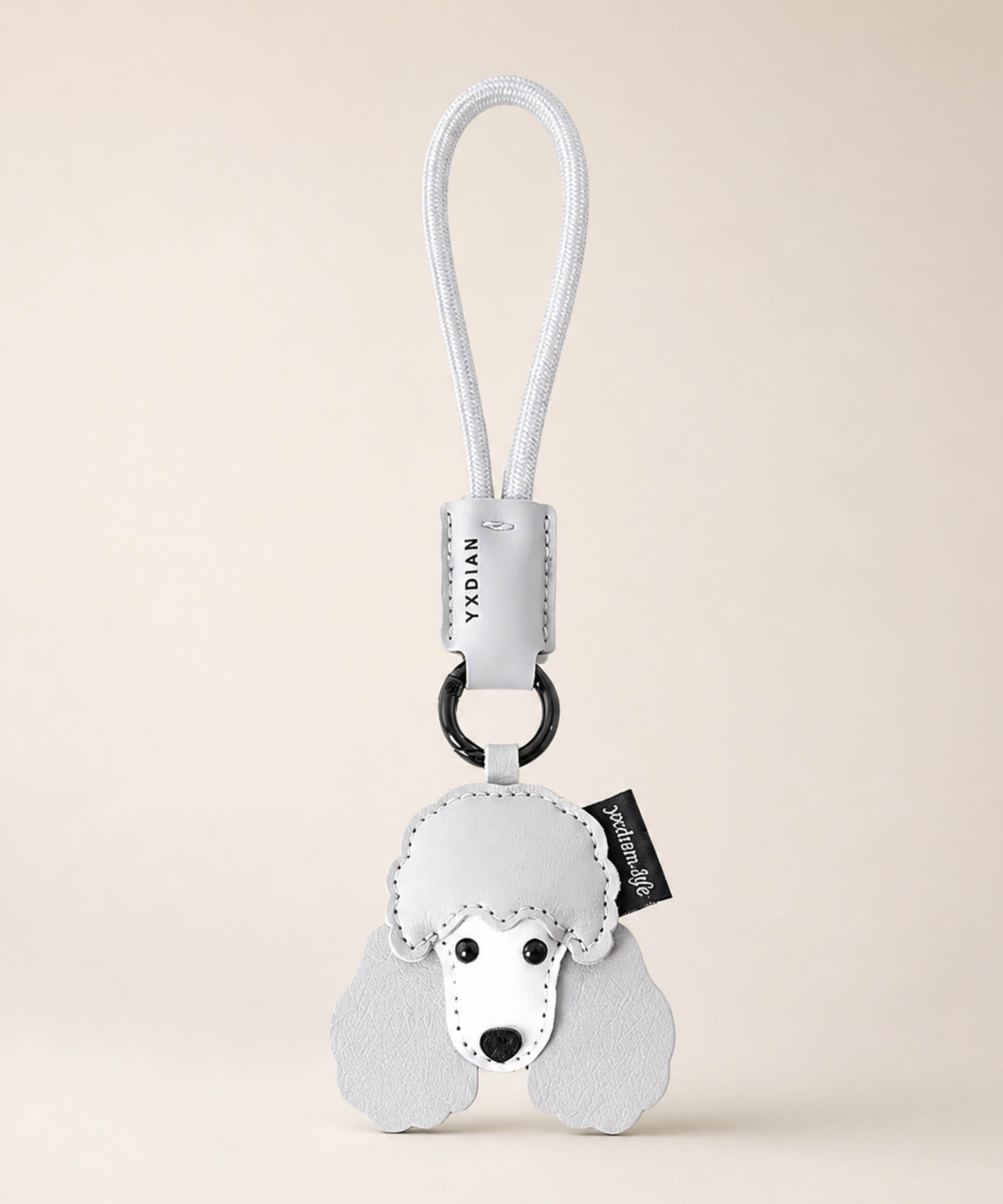 Poodle pet face PU leather bag charm keychain on a neutral background.