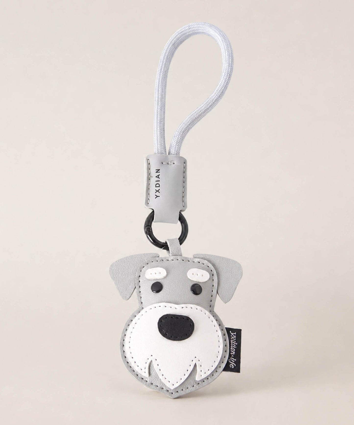 Schnauzer pet face PU leather bag charm keychain on a neutral background.