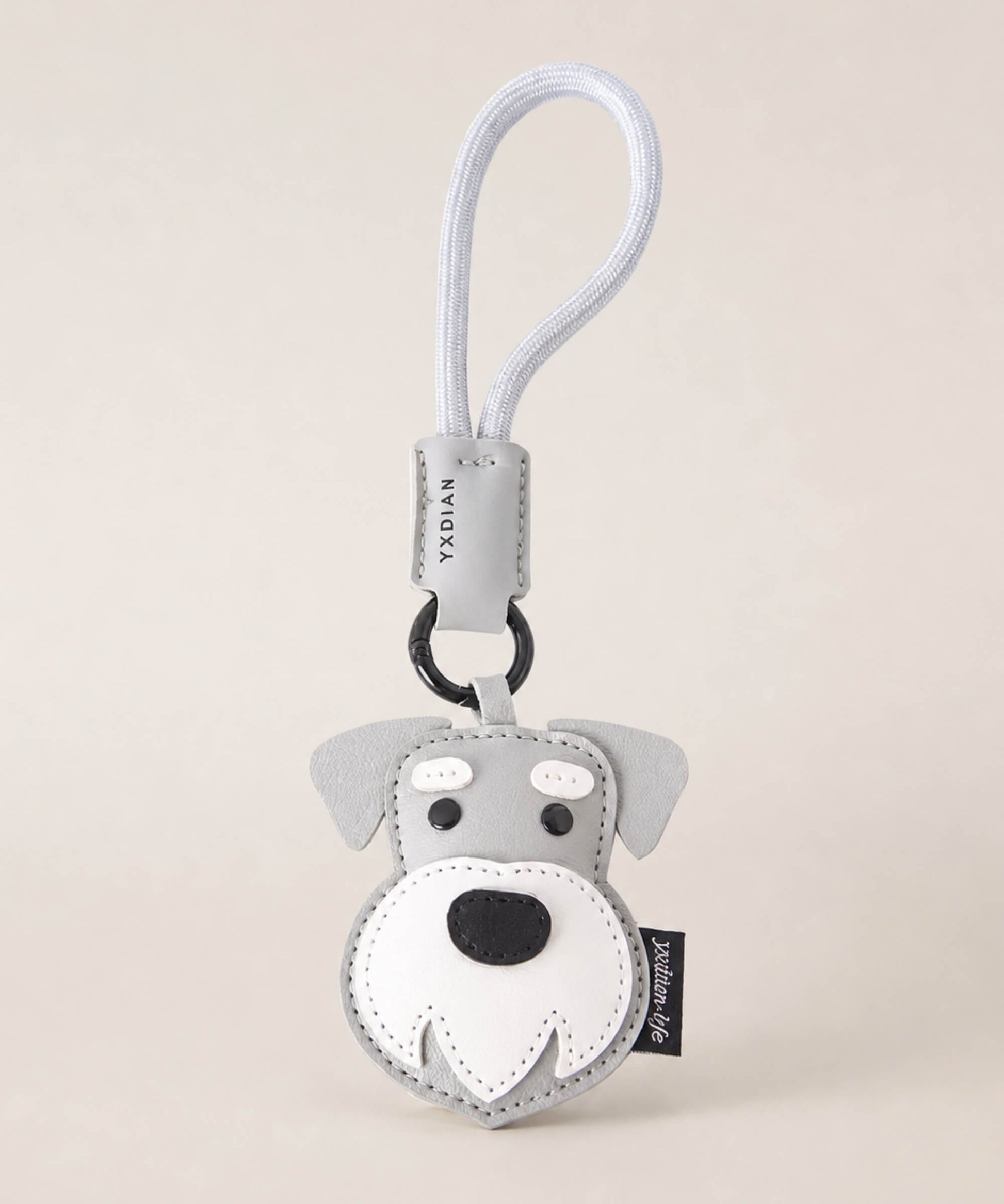 Schnauzer pet face PU leather bag charm keychain on a neutral background.