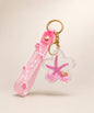 Pink starfish liquid keychain with pink glitter, shell detail, floral strap and gold hardware