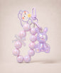 Purple bunny beaded keychain with iridescent rabbit charm and bow detail on a neutral background