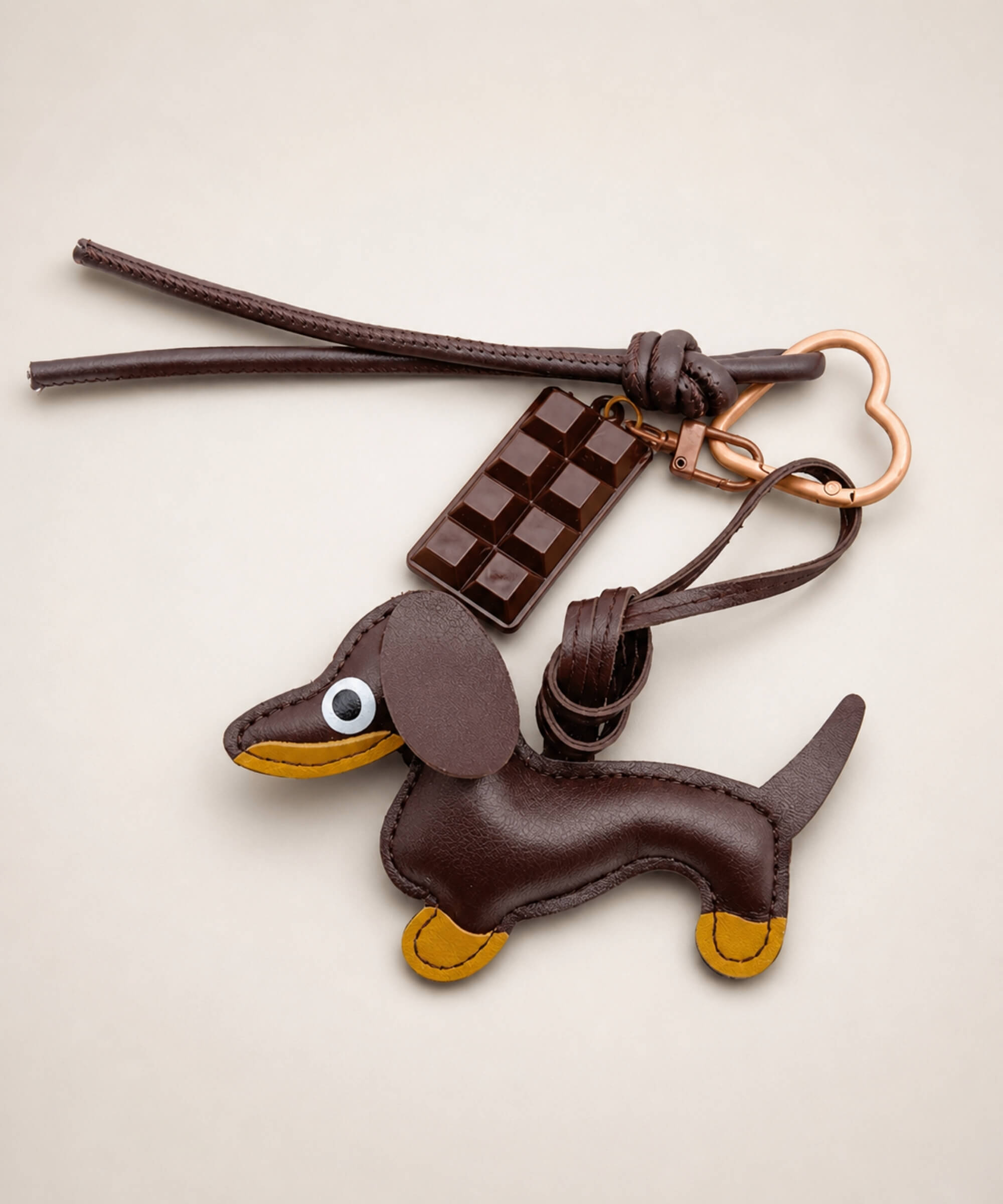 Brown sausage dog PU leather bag charm keychain with a chocolate charm styled on a neutral background.