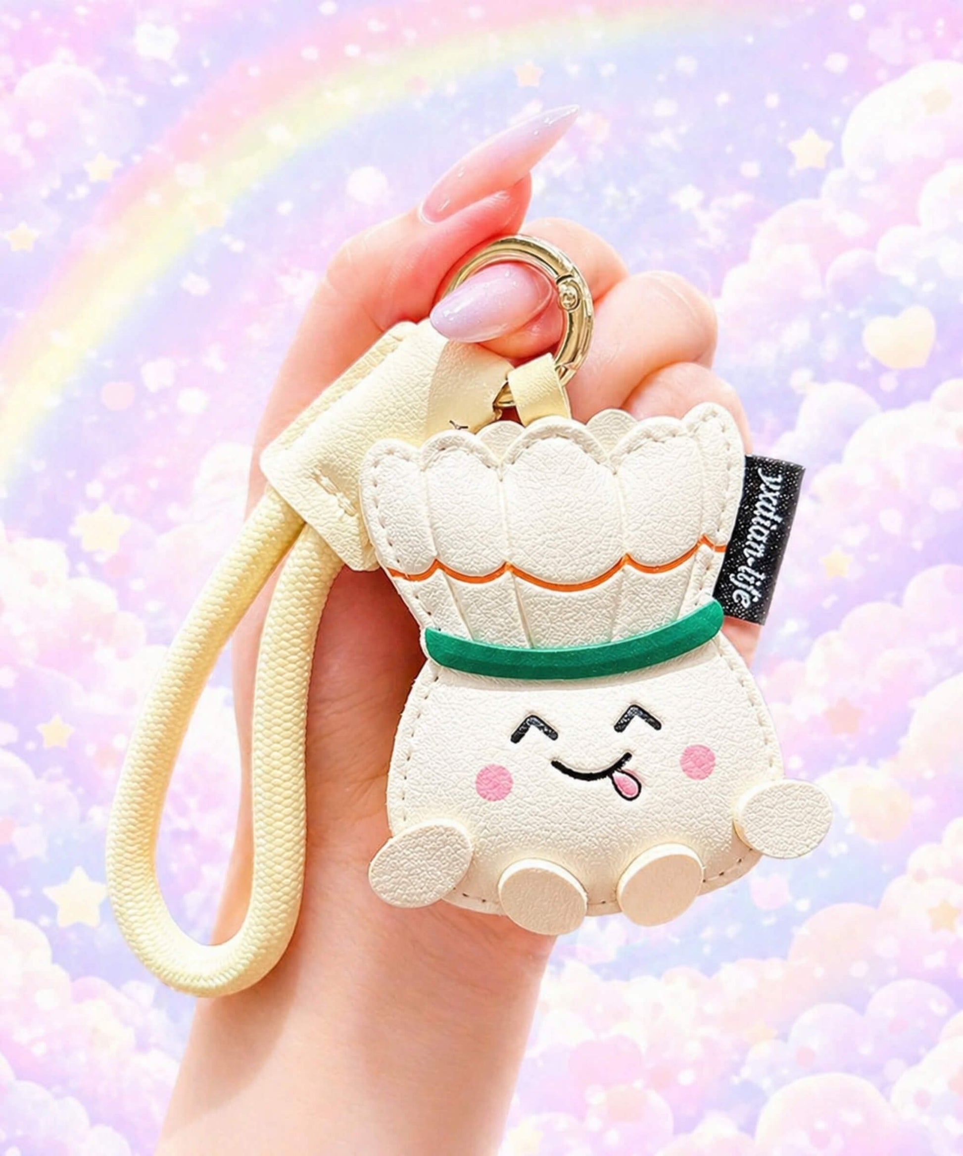 Badminton PU leather bag charm keychain held in hand against a pastel rainbow background.