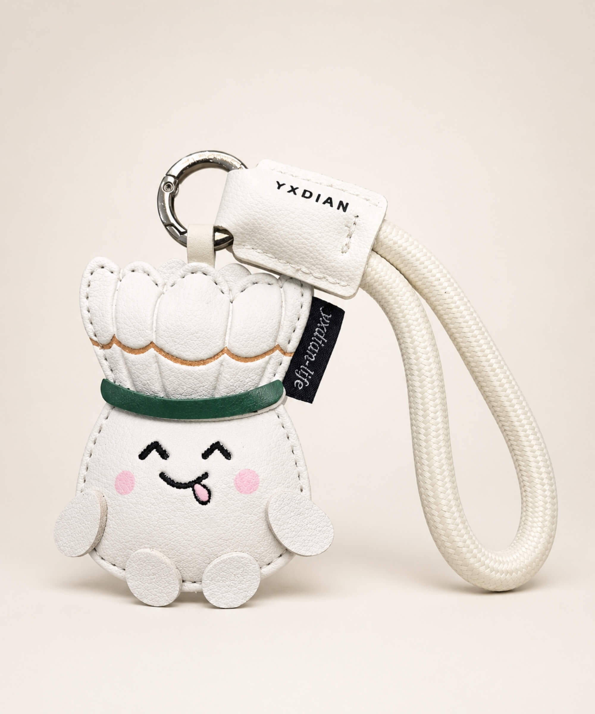White badminton PU leather bag charm keychain with cream wrist strap on a neutral studio background.