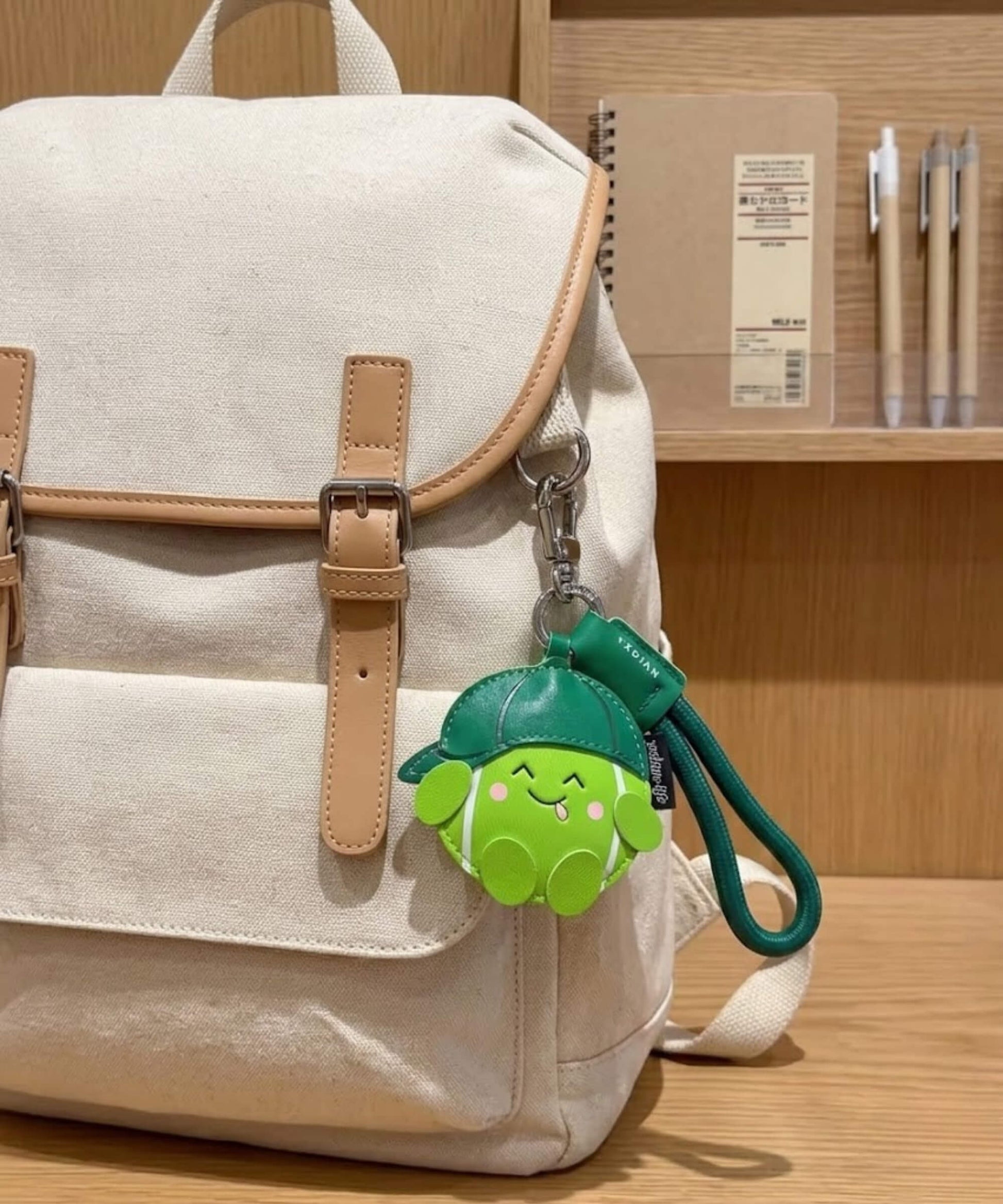 Tennis PU leather bag charm keychain attached to a backpack in a lifestyle
