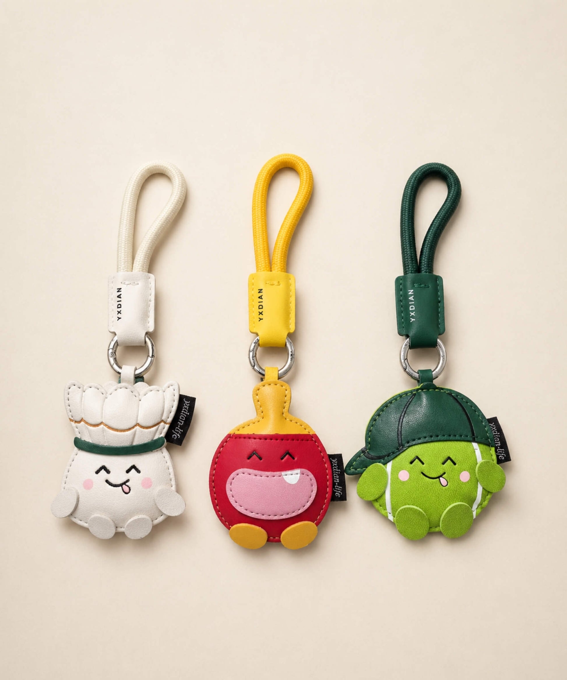 Sports PU leather bag charm keychains in tennis, badminton and table tennis designs on a studio background.