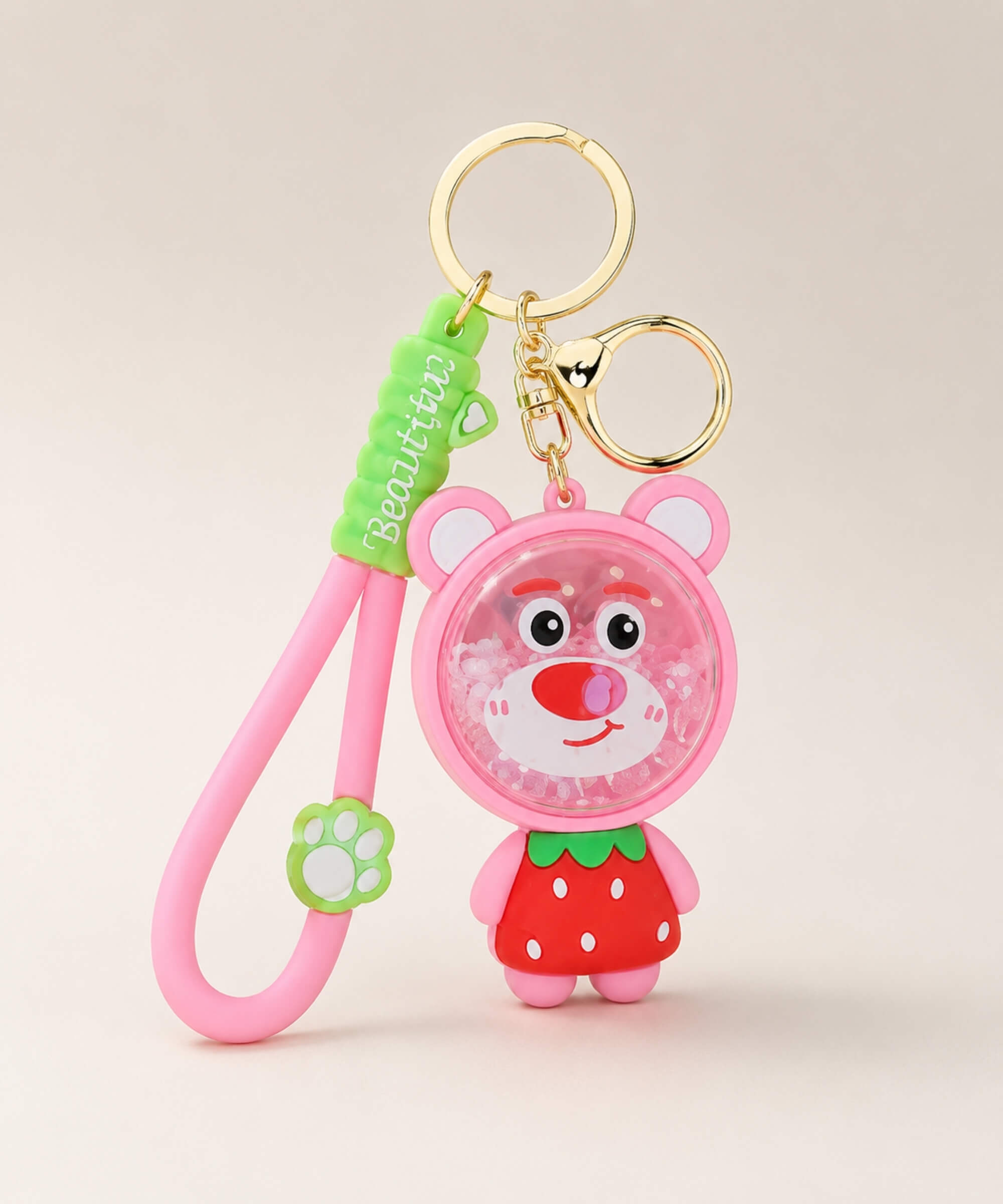 Strawberry Bear bead shaker keychain with pink strap and gold hardware on a neutral background