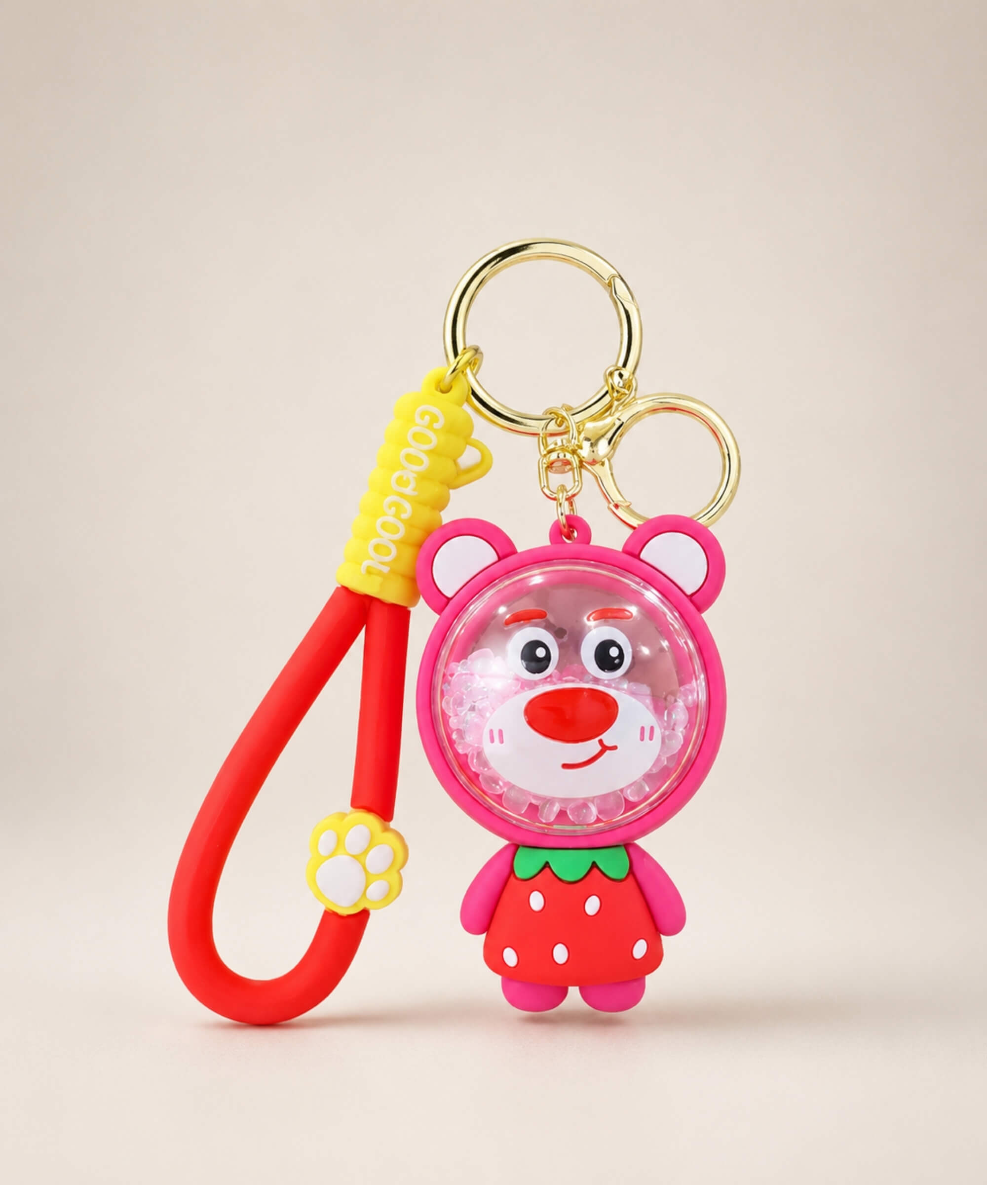 Strawberry Bear bead shaker keychain with red strap and gold hardware on a neutral background