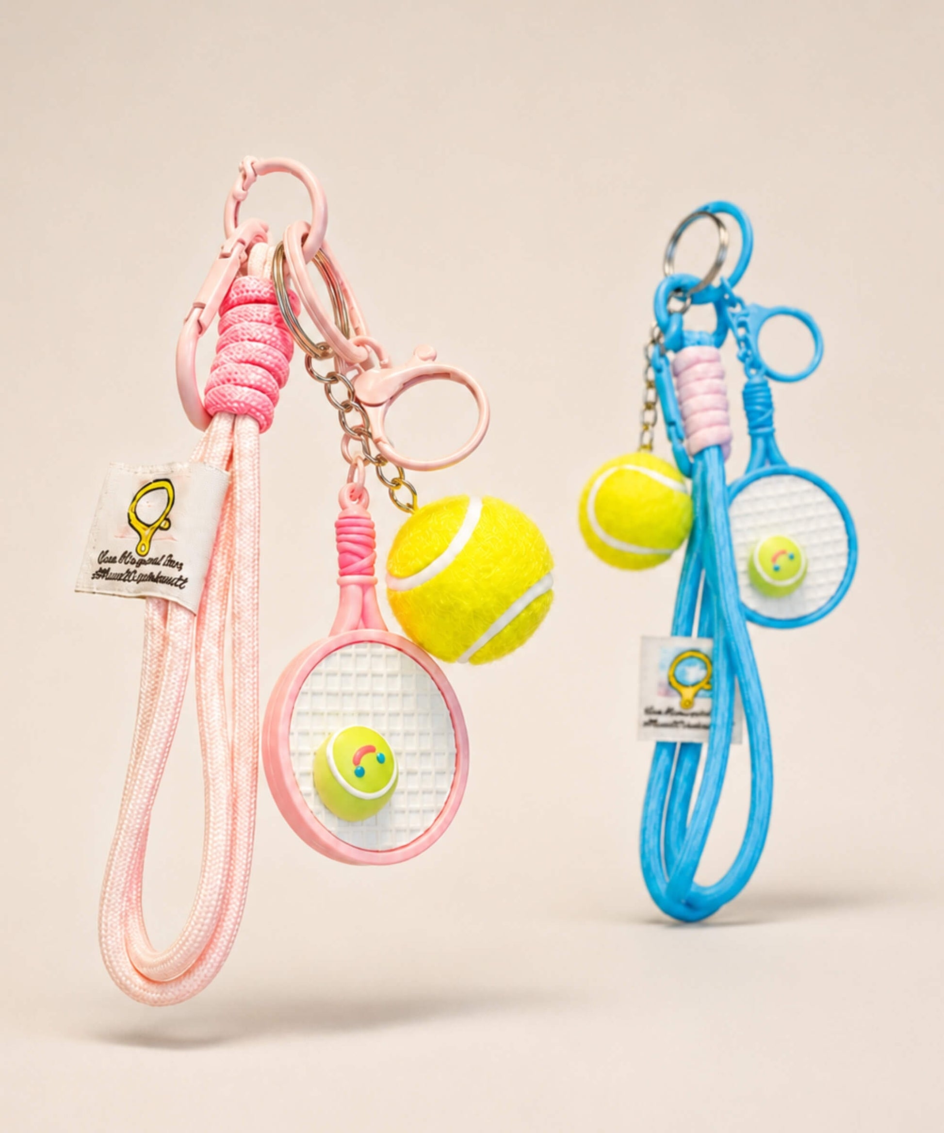 Pink and blue tennis racket rope keychains with tennis ball charms and long cord straps