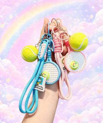 Pink and blue tennis racket rope keychains held by hand with pastel rainbow background