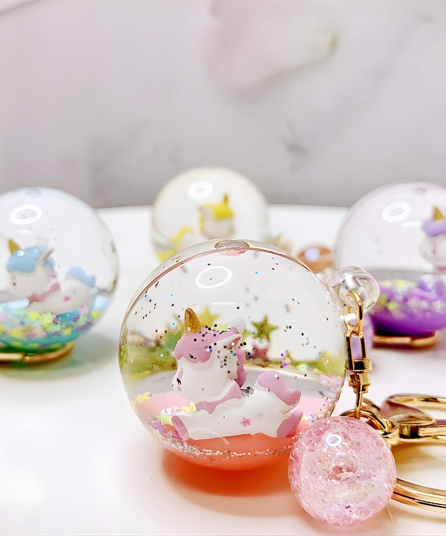 Unicorn liquid glitter keychain in pink blue and yellow with floating glitter effect
