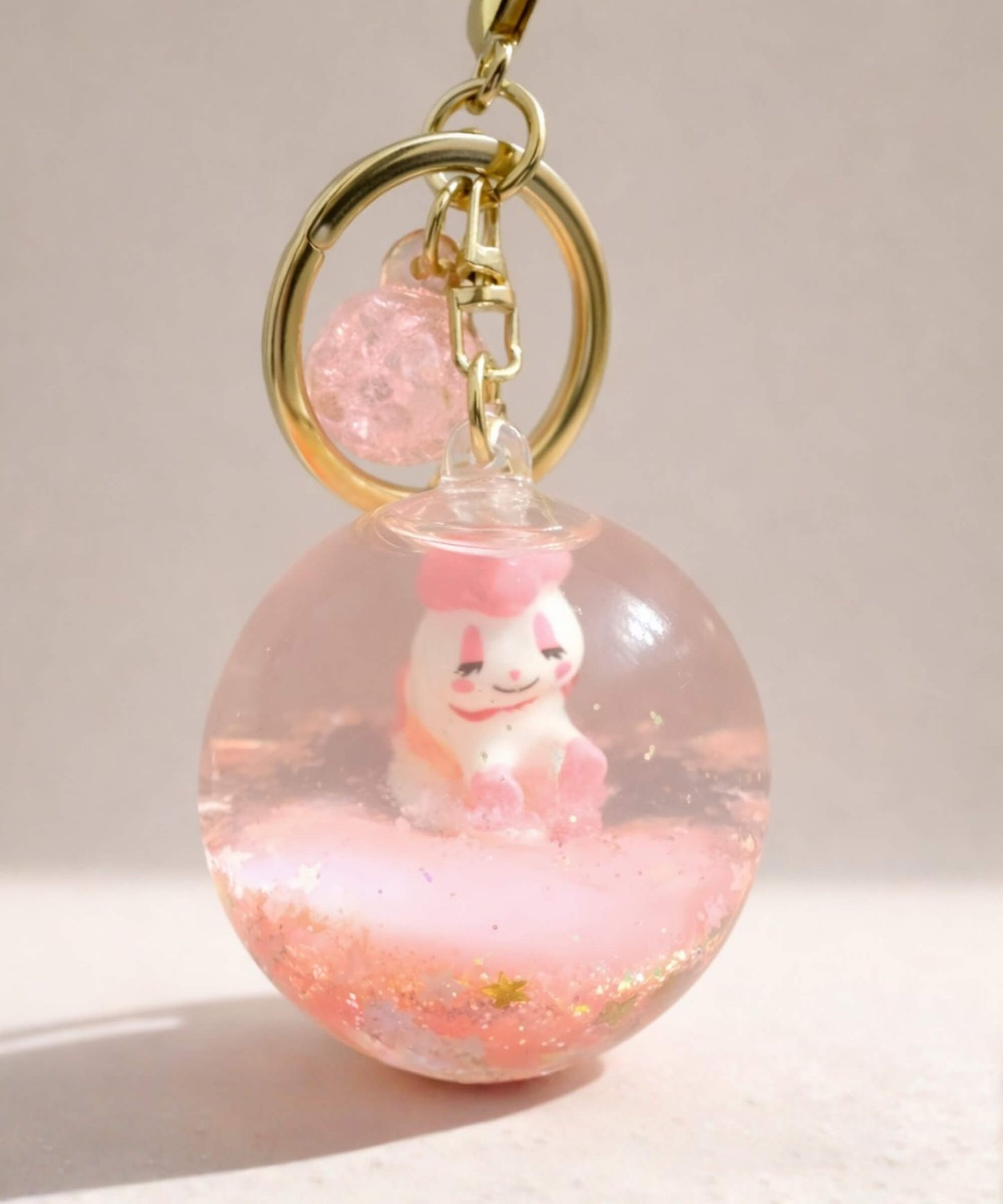 Pink unicorn liquid glitter keychain with floating shimmer effect and cute character inside