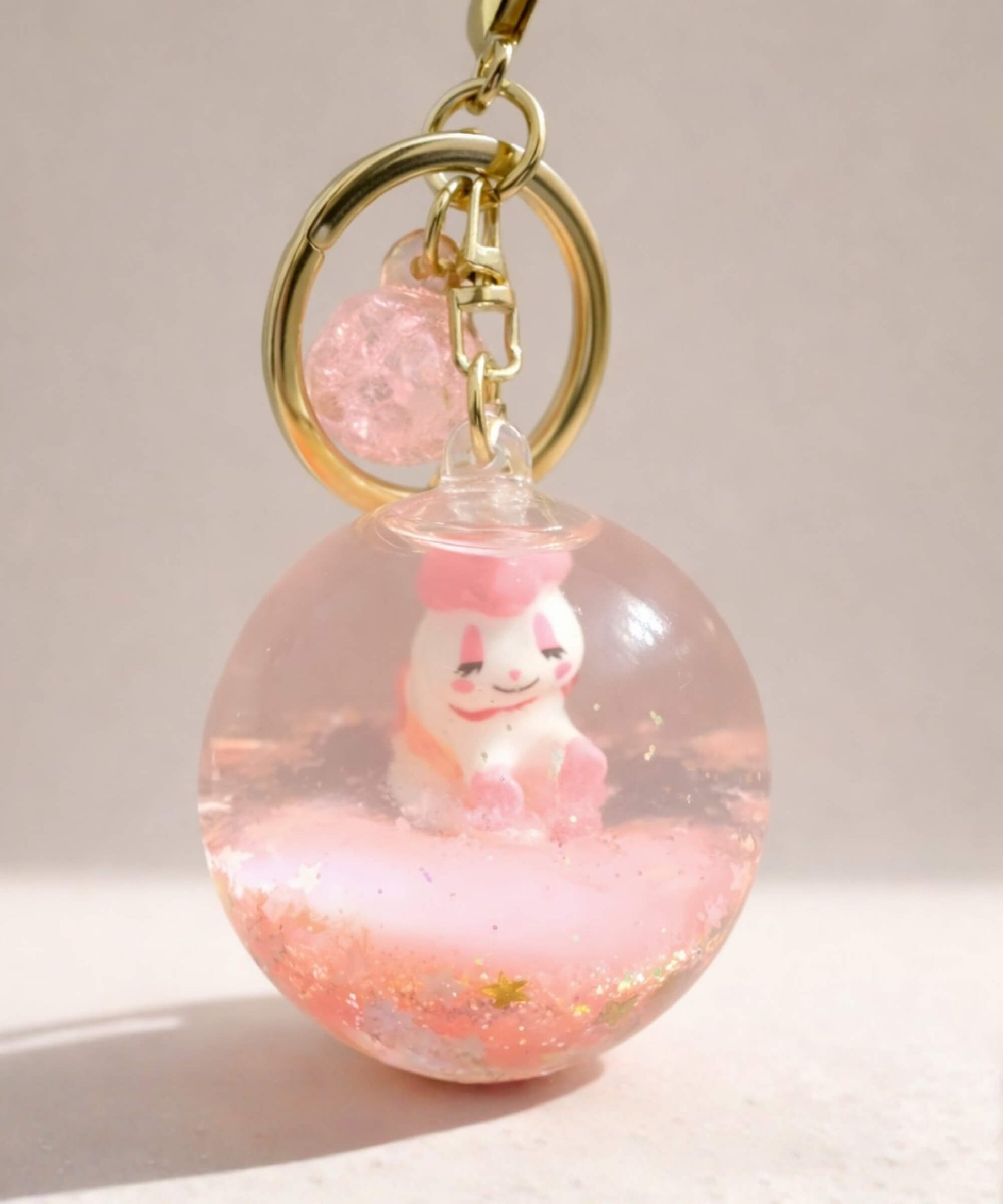 Pink unicorn liquid glitter keychain with floating shimmer effect and cute character inside