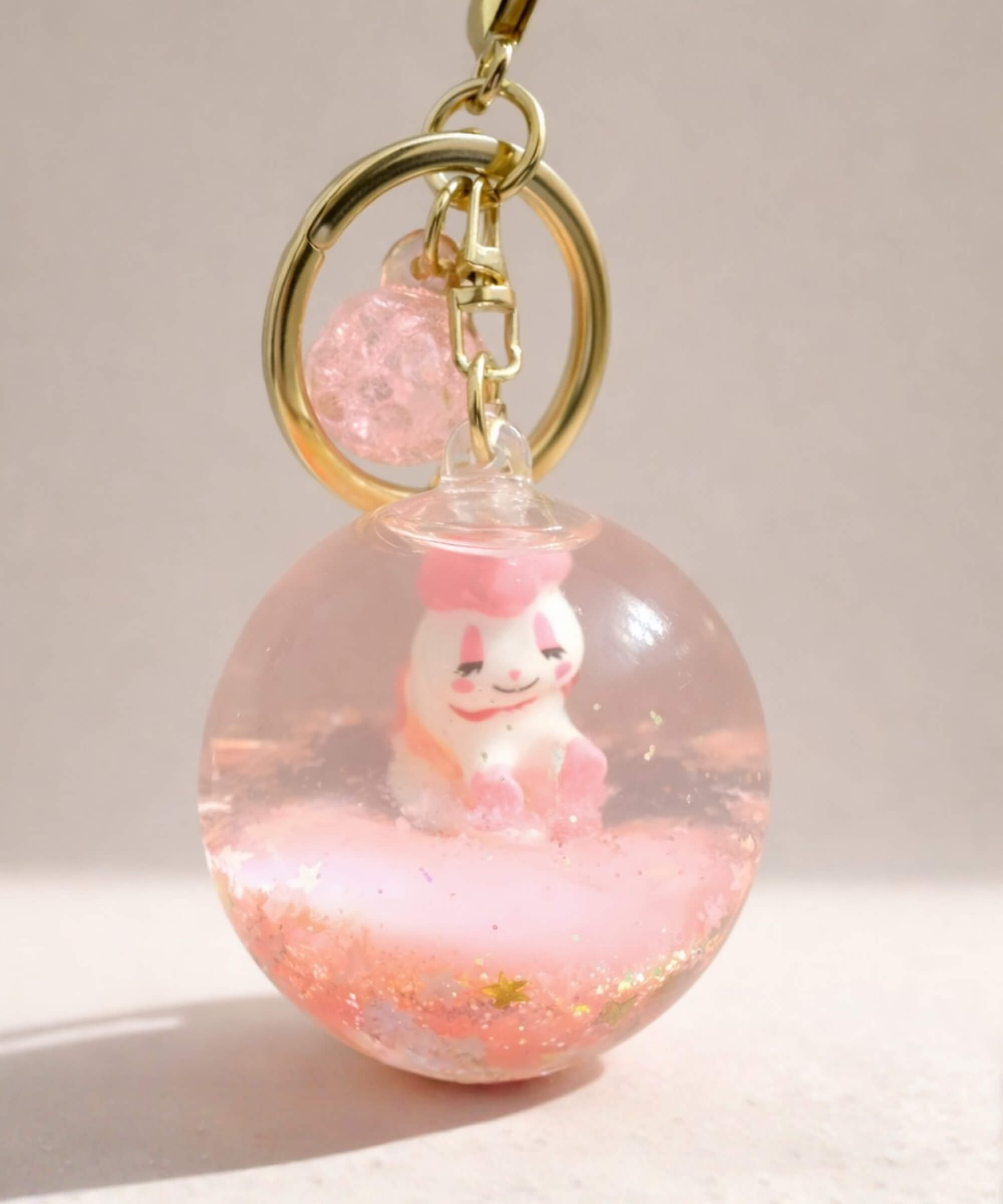 Pink unicorn liquid glitter keychain with floating shimmer effect and cute character inside