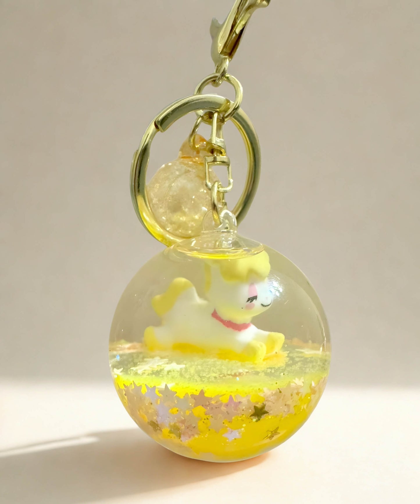 Yellow unicorn liquid glitter keychain with floating glitter and crystal ball design