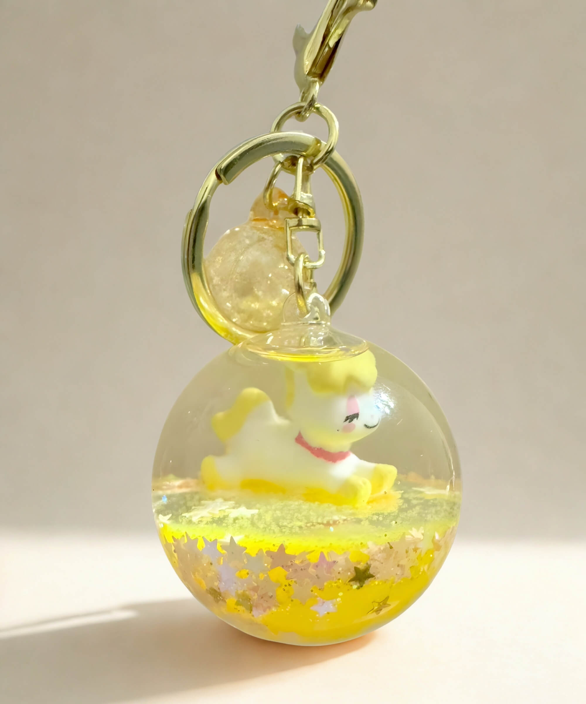 Yellow unicorn liquid glitter keychain with floating glitter and crystal ball design