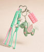Green unicorn PU leather bag charm keychain with pink wing, star charms and pink chocolate charm.