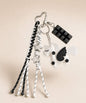 White unicorn PU leather bag charm keychain with black wing, star charms and black chocolate charm.