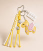 Yellow unicorn PU leather bag charm keychain with pink wing, star charms and white chocolate charm.