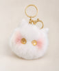 Yellow eye cat plush keychain with white fluffy body, yellow star eyes, pink cheek detail and gold hardware