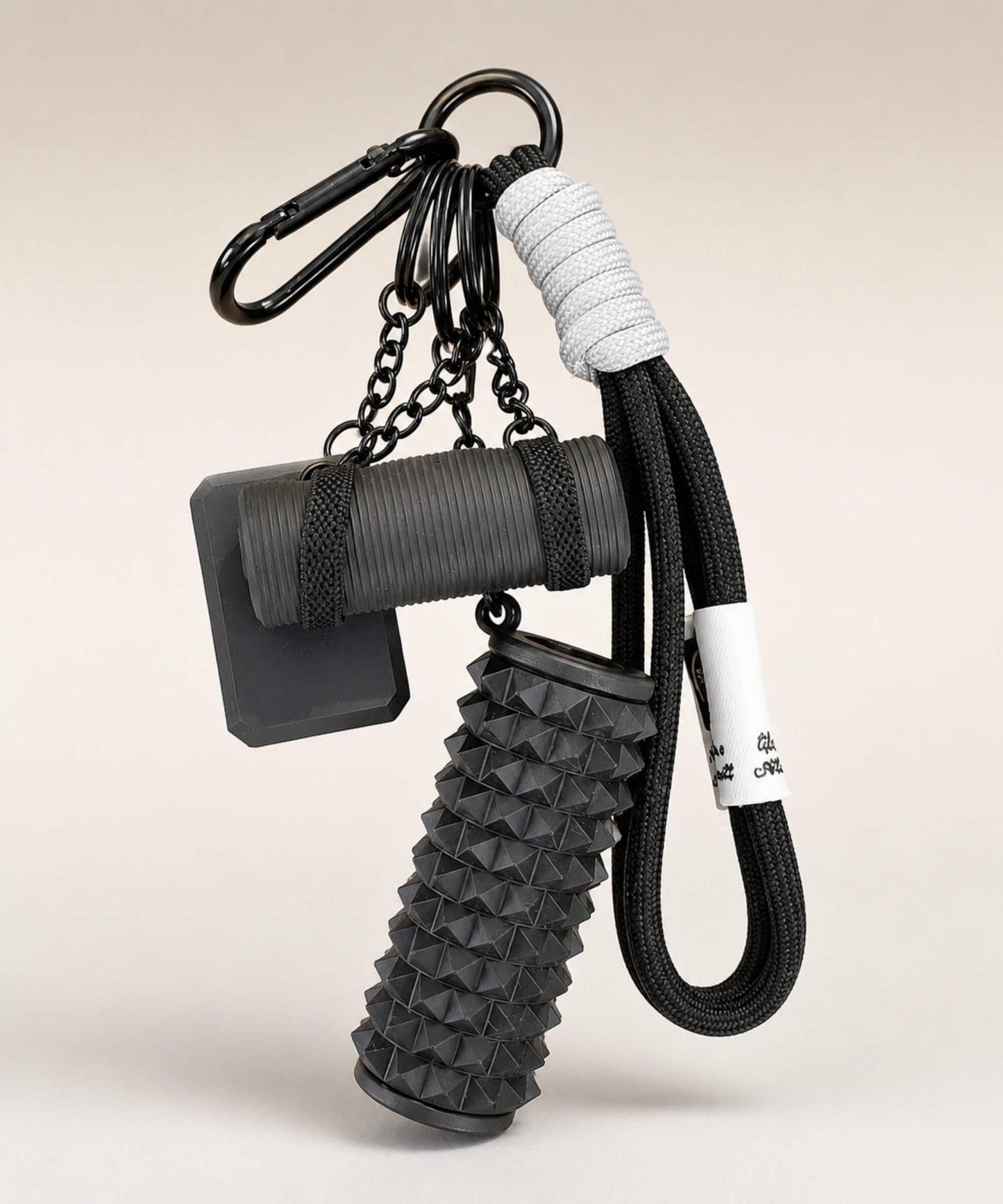 Black yoga rope keychain with black foam roller charm and black yoga mat charm on a neutral background