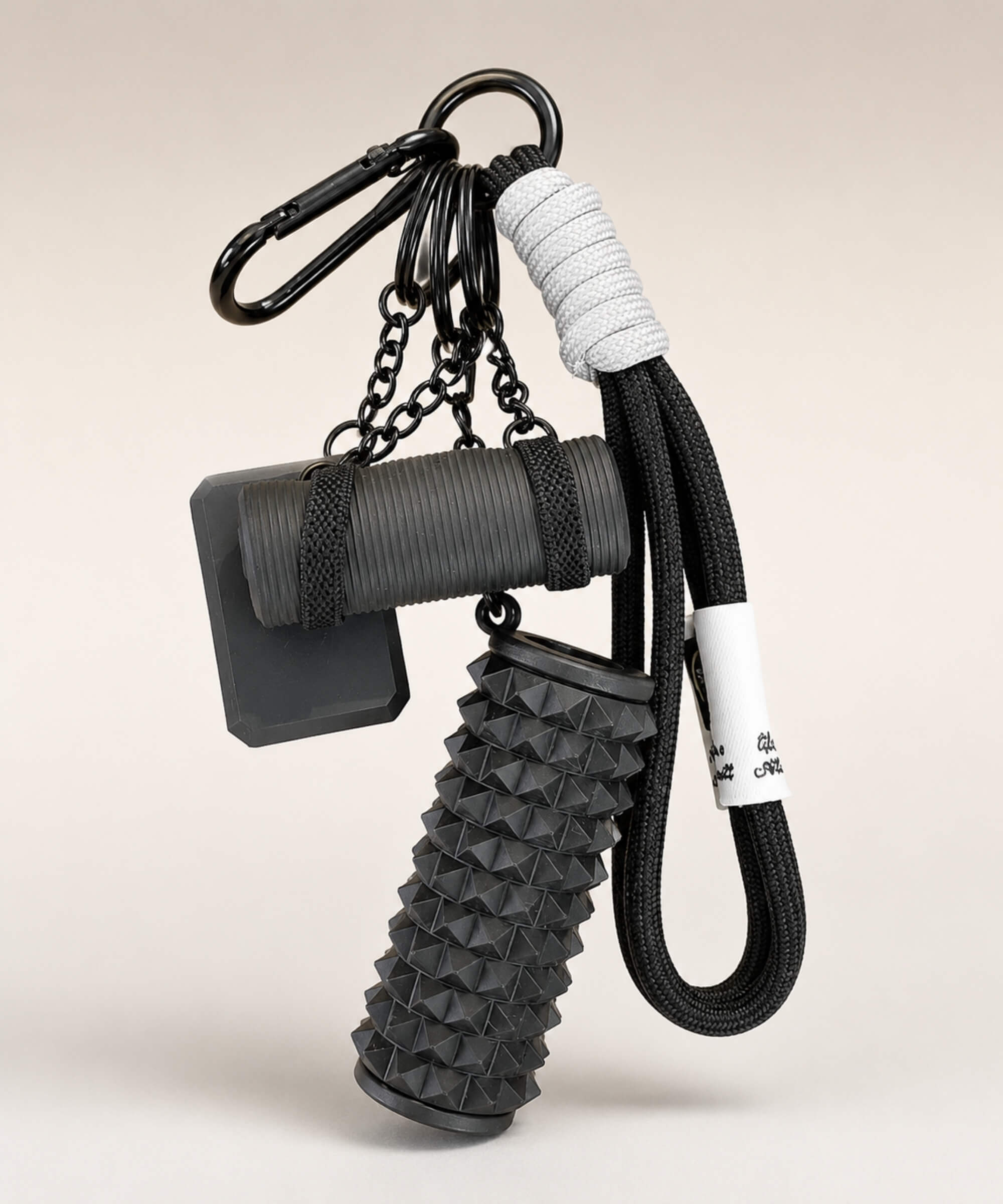 Black yoga rope keychain with black foam roller charm and black yoga mat charm on a neutral background