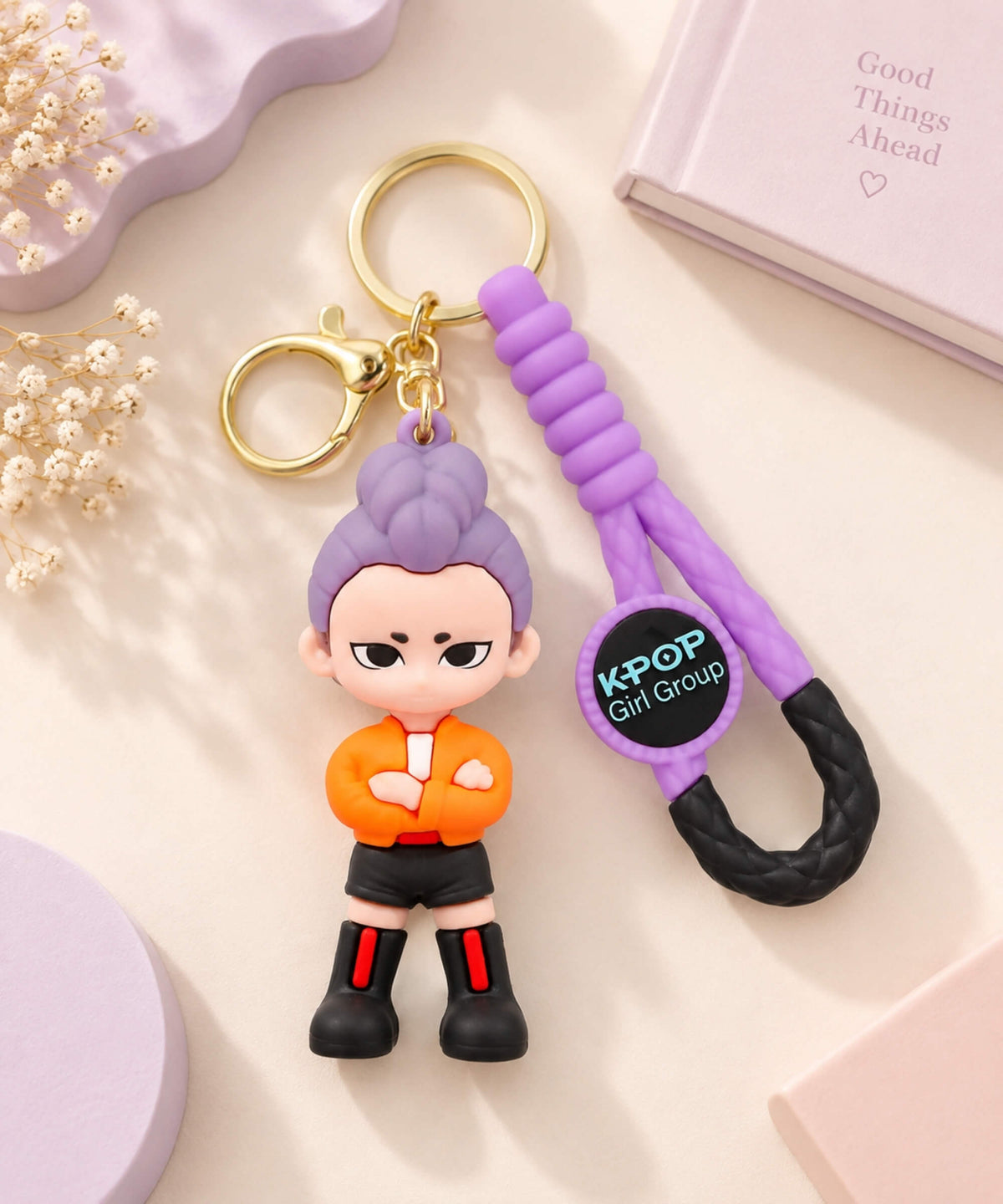 Brimstone K-pop style demon hunter character keychain with purple hair, orange outfit, braided wrist strap and gold-tone hardware