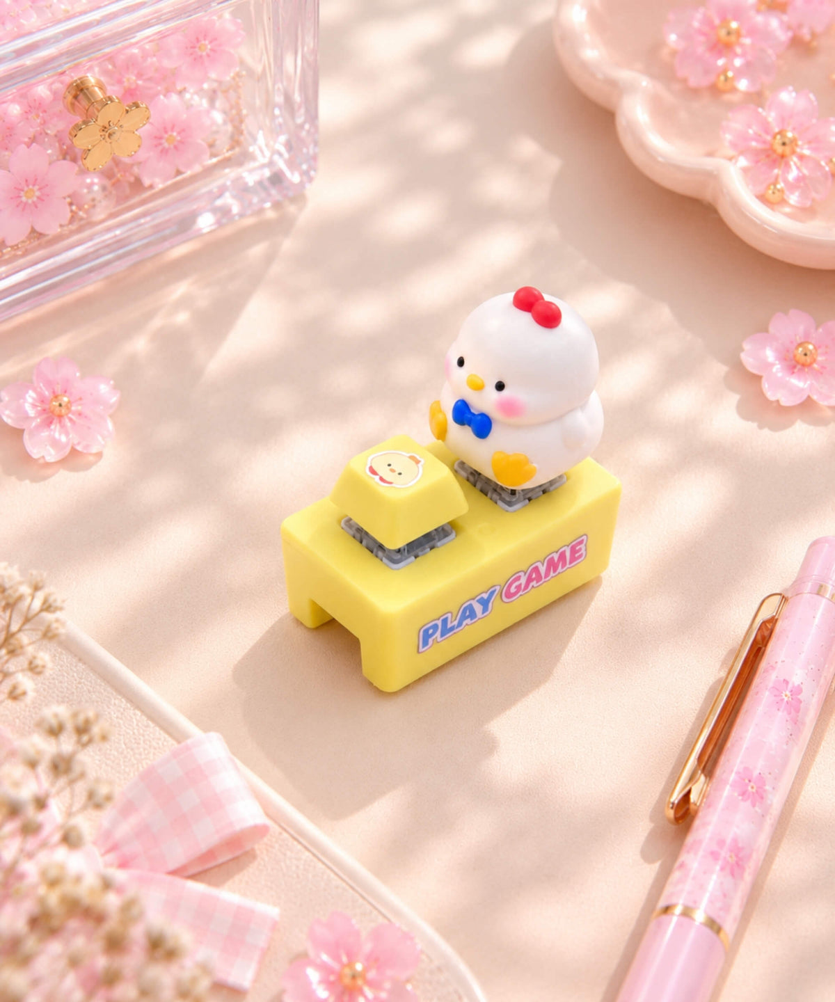 White chick sound and light button keychain styled on a pink desk