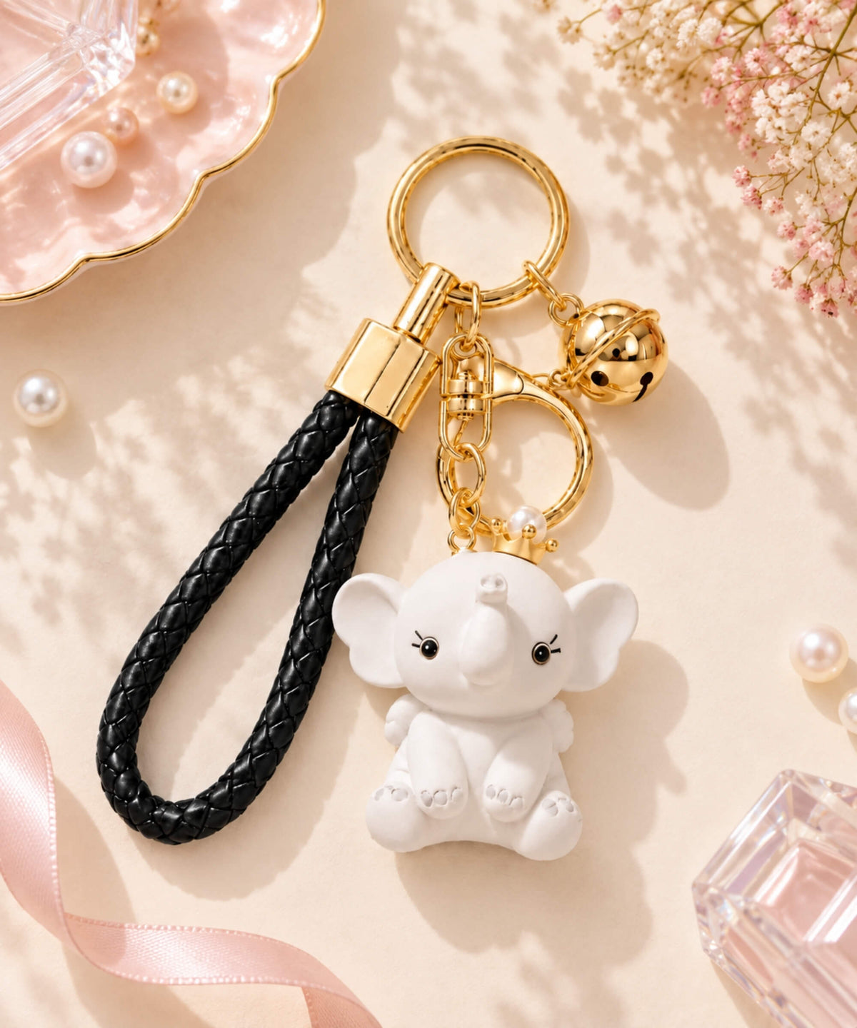 Grey crown elephant resin keychain with black braided strap, bell and gold-tone hardware