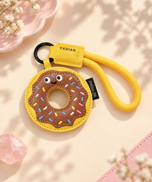 Chocolate Donut PU leather bag charm keychain with yellow rope loop on a soft neutral background