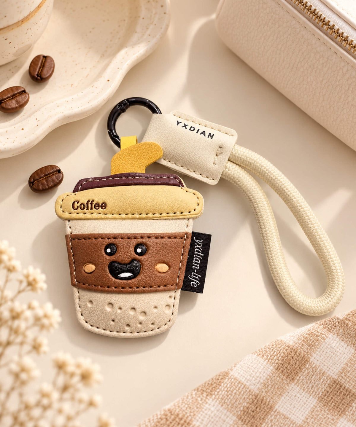Coffee cup PU leather bag charm keychain styled with coffee beans on a warm neutral background
