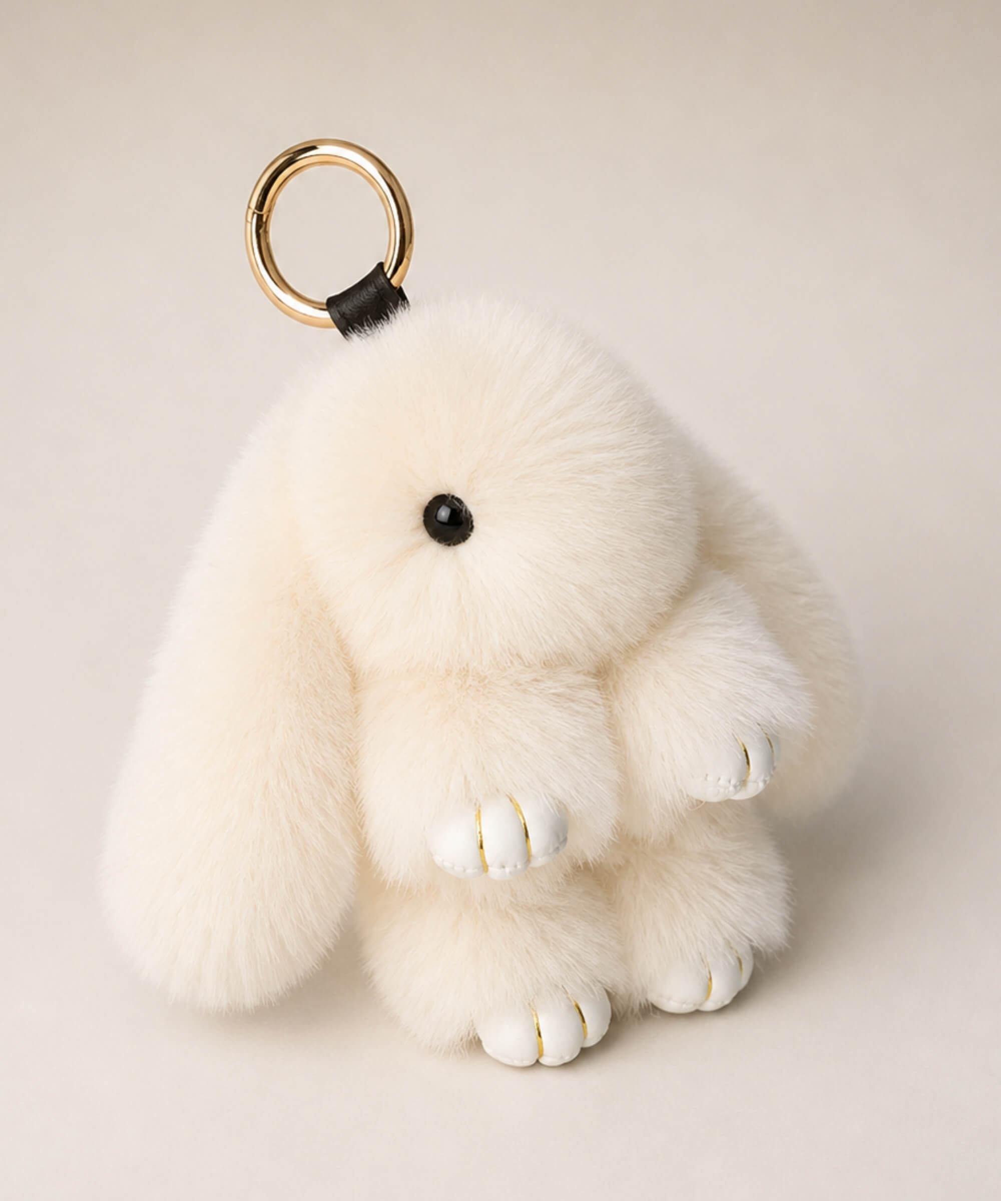 Beige fluffy bunny plush keychain with floppy ears and gold-tone keyring