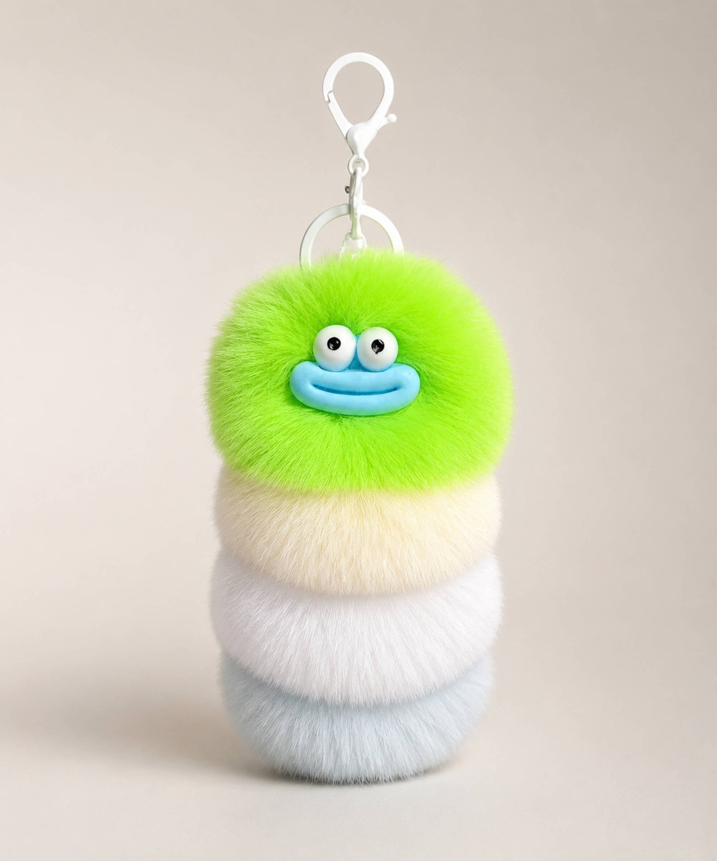 Green fluffy caterpillar plush keychain with green, cream, white and pale blue layers