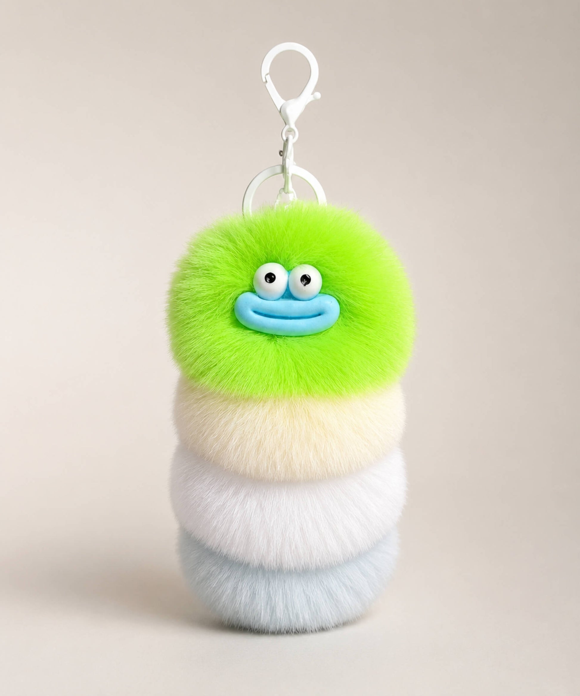 Green fluffy caterpillar plush keychain with green, cream, white and pale blue layers