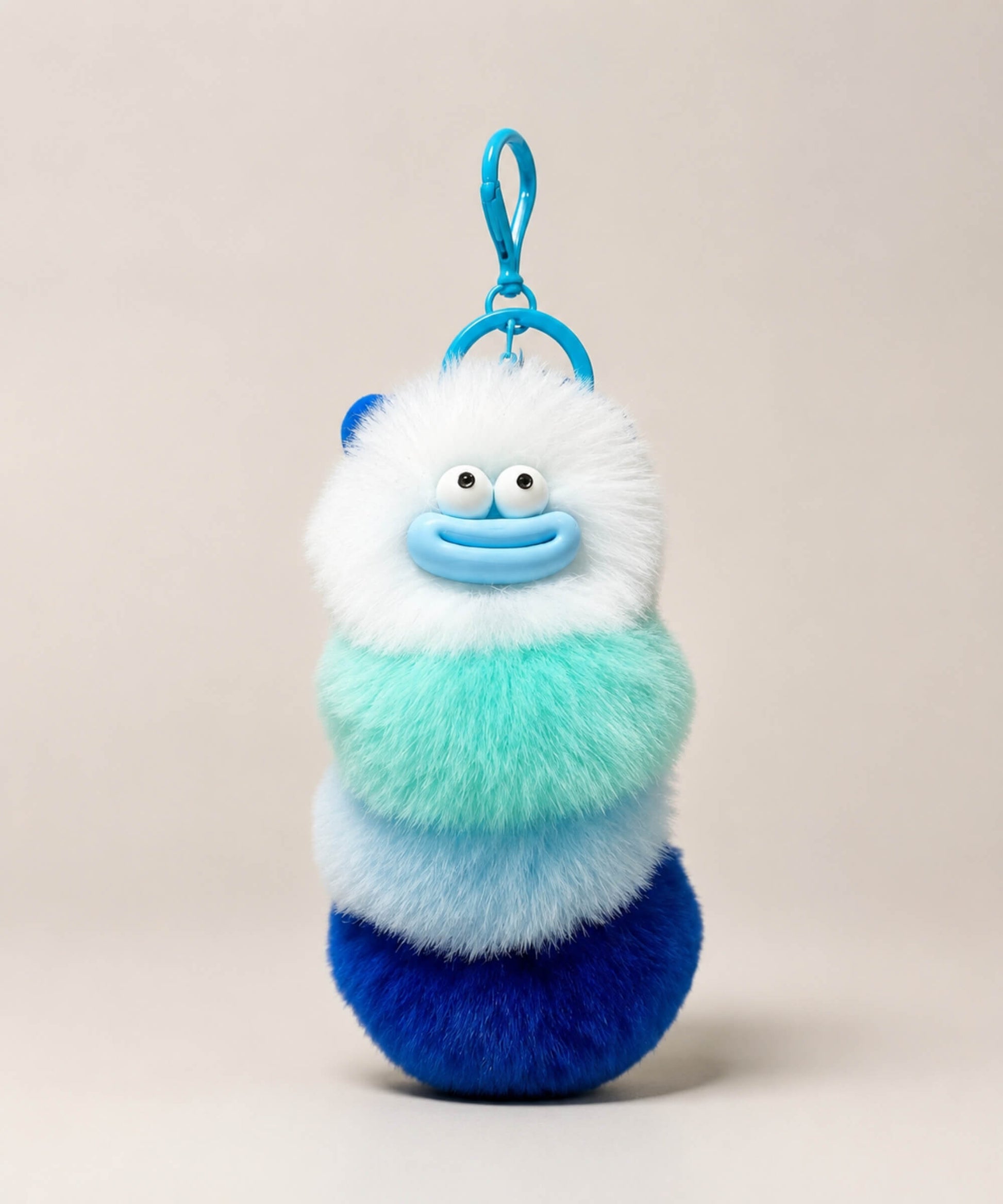 White fluffy caterpillar plush keychain with white, mint, blue and navy layers
