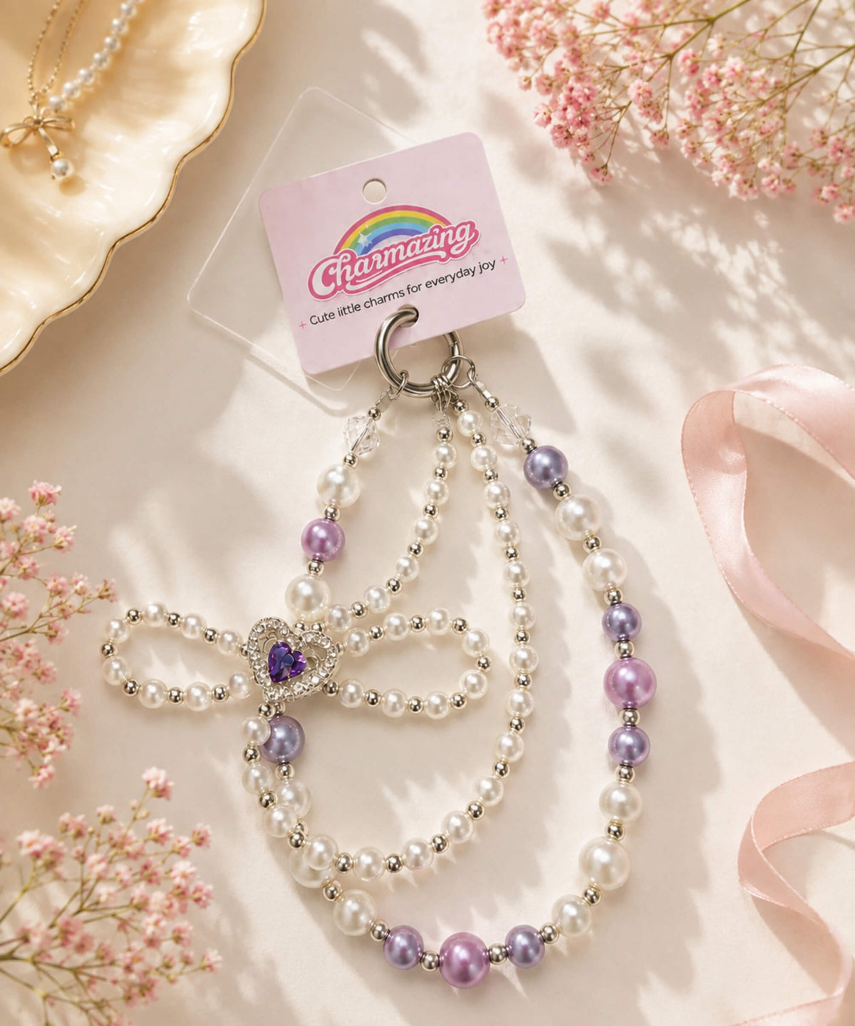 Purple heart bow beaded phone charm with pearl-look beads styled in a soft pink setting