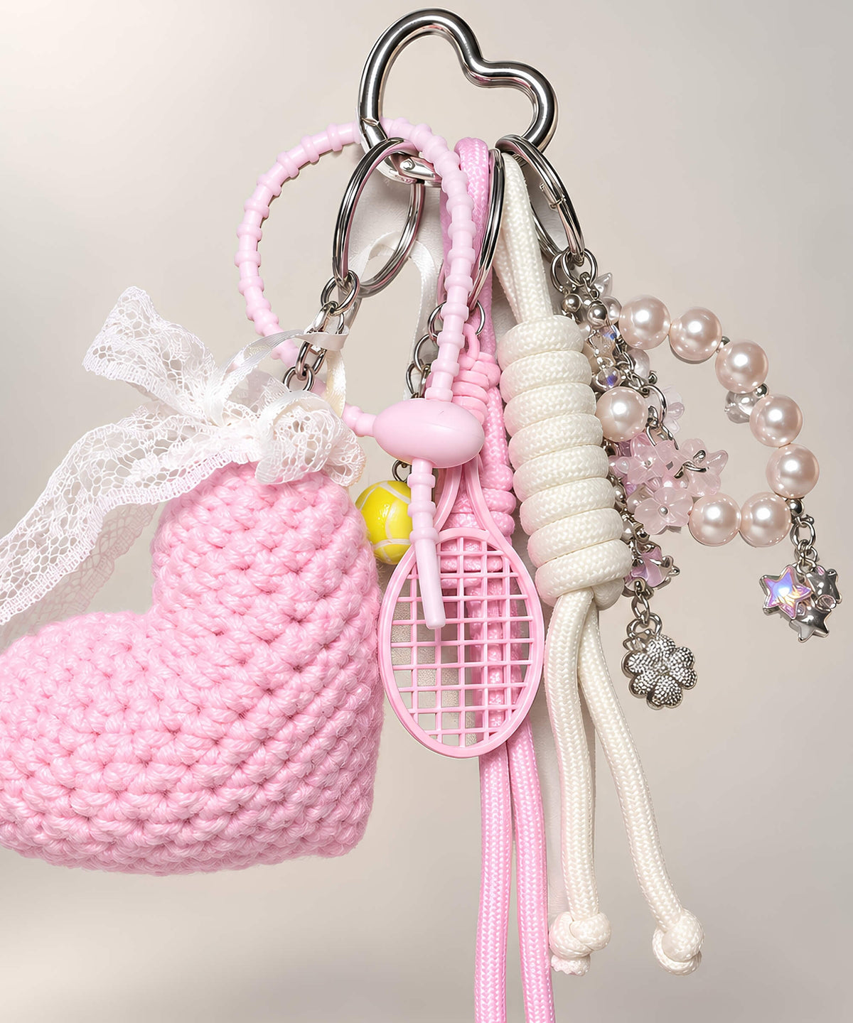 Close-up of pink heart crochet keychain with pearl-style beads and lace details