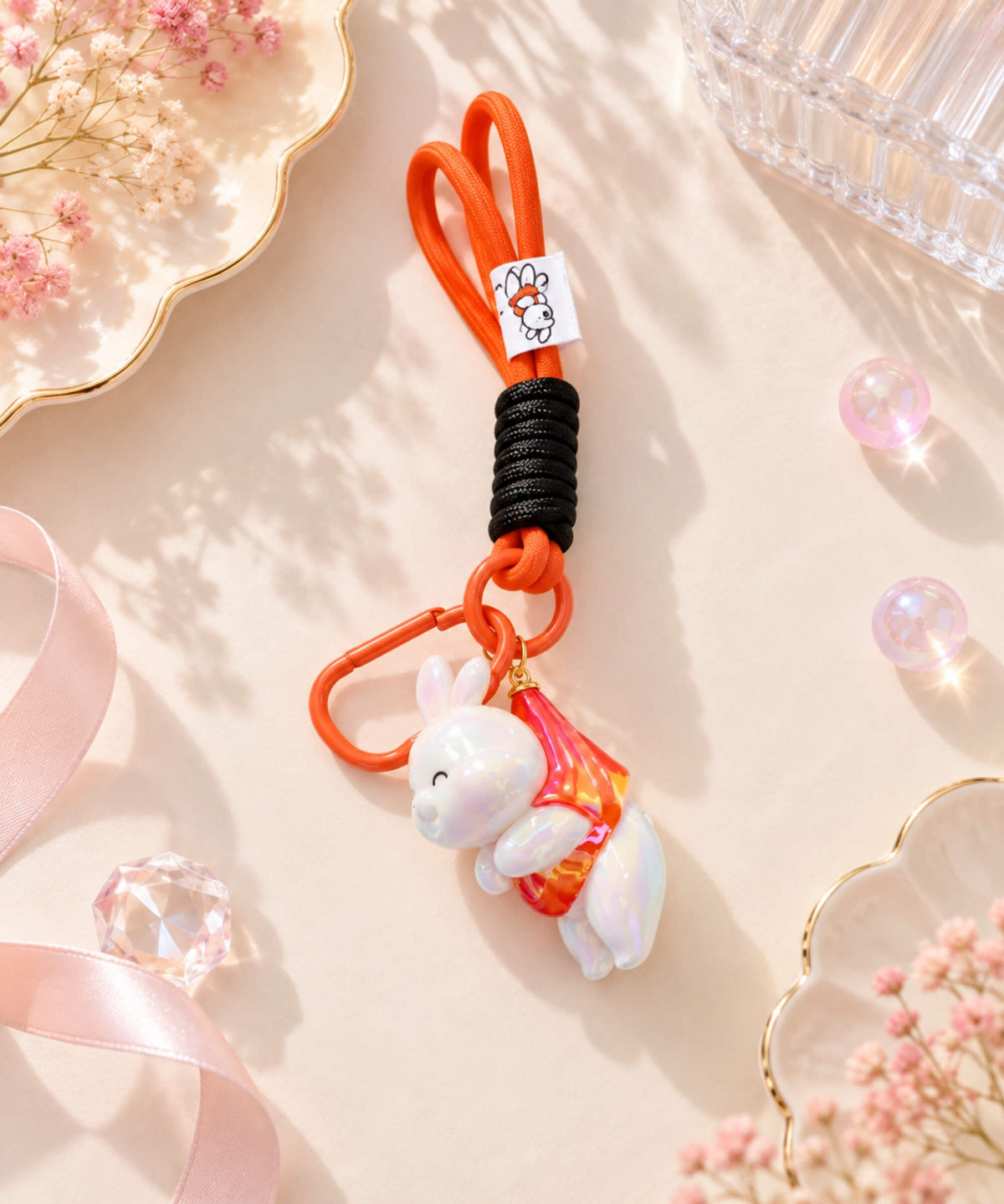 Iridescent bunny resin keychain with red accent detail, red cord strap and matching clip