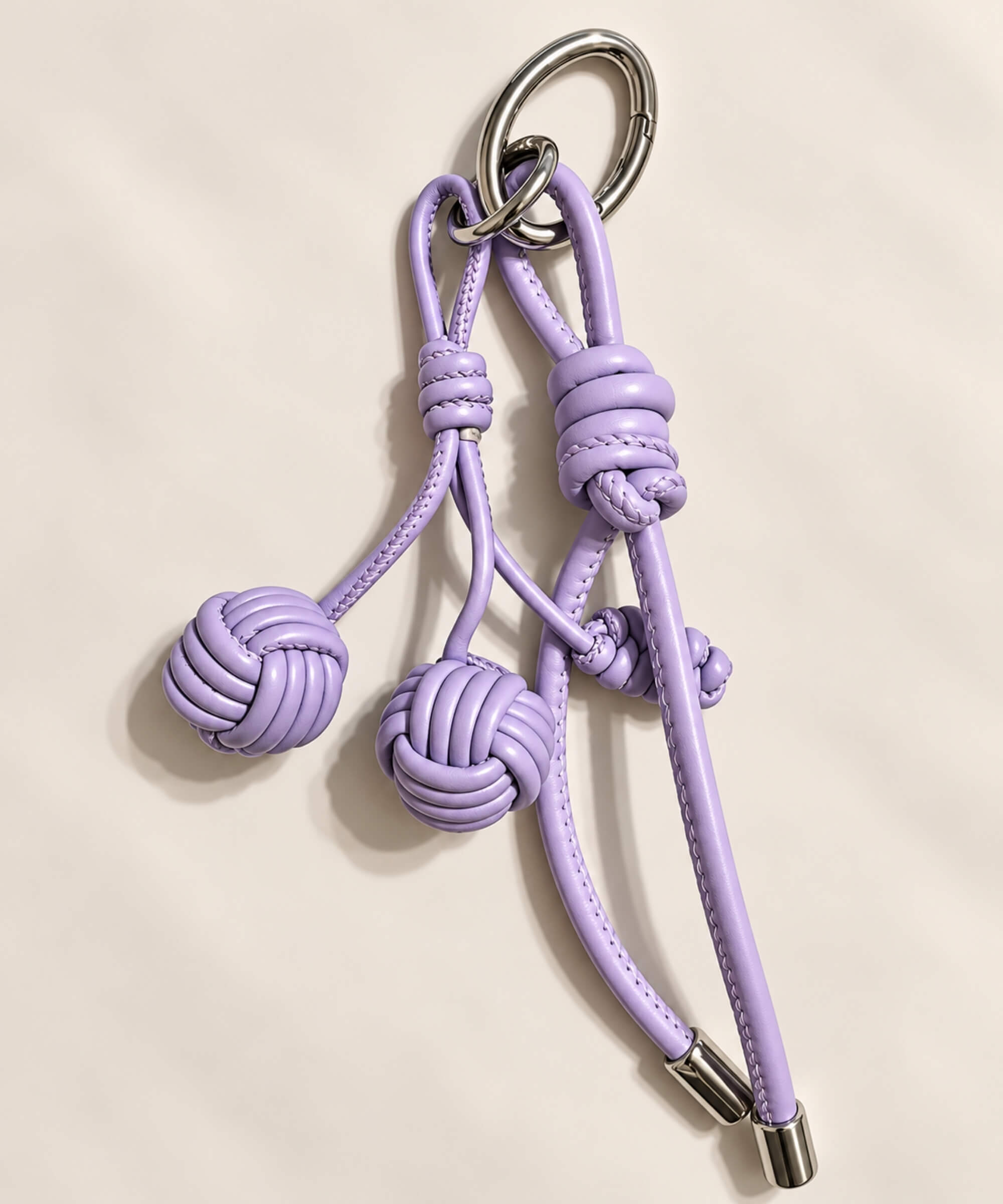Close-up of purple knotted ball PU leather bag charm keychain with woven ball accents