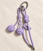 Close-up of purple knotted ball PU leather bag charm keychain with woven ball accents